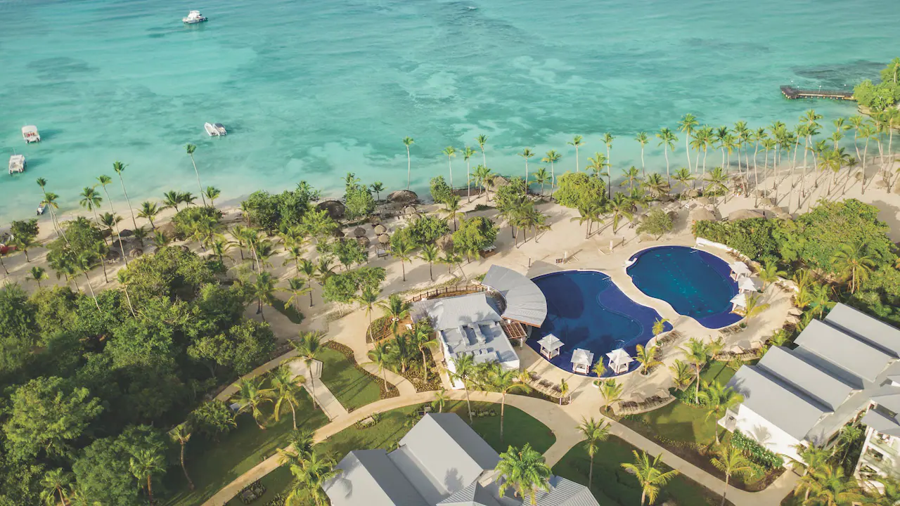 Aerial view of beachfront pools and turquoise Caribbean waters at Secrets La Romana Resort & Spa.