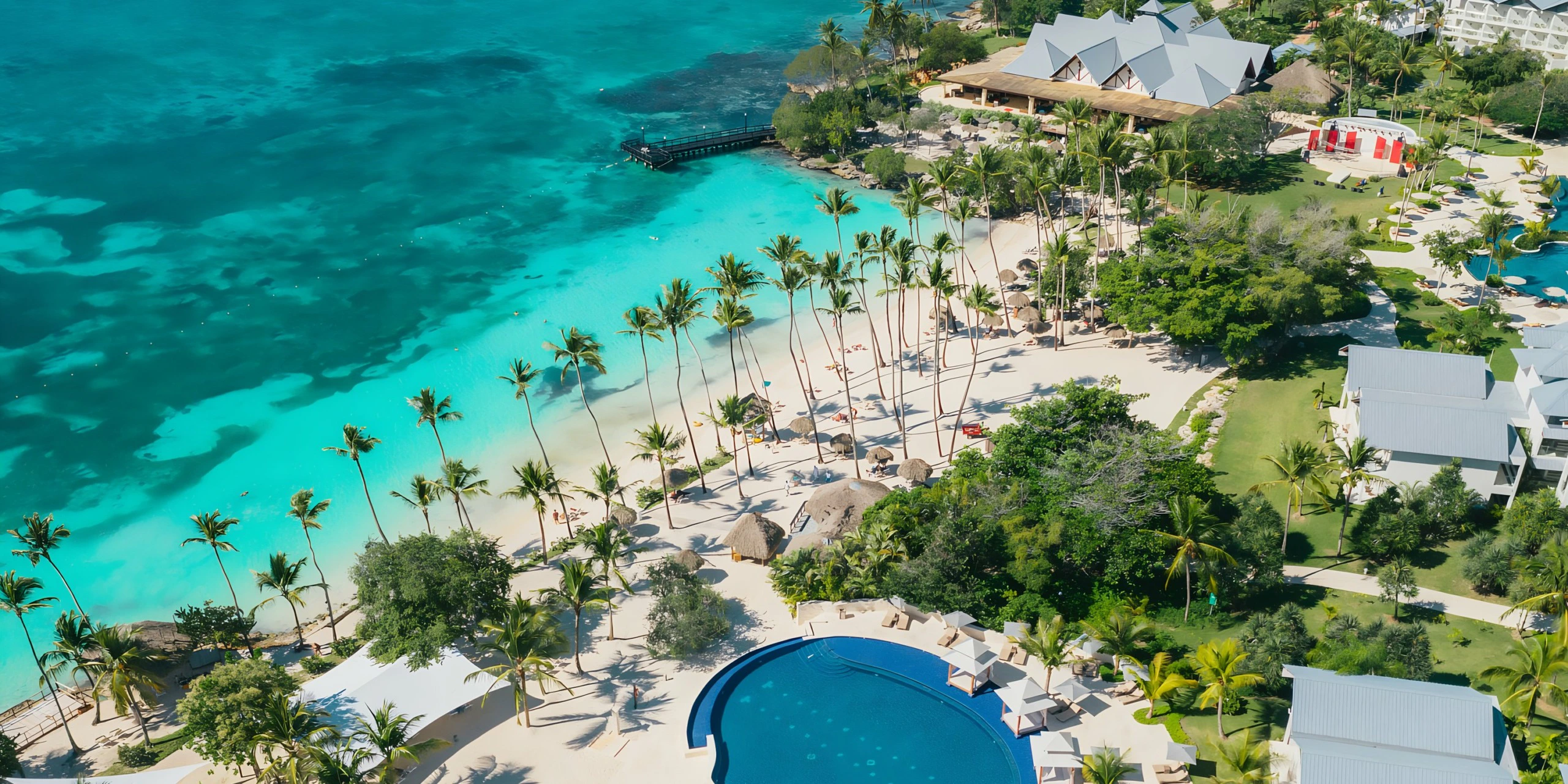Aerial beachfront view of Secrets La Romana Resort & Spa with turquoise Caribbean waters and palm-lined beach.
