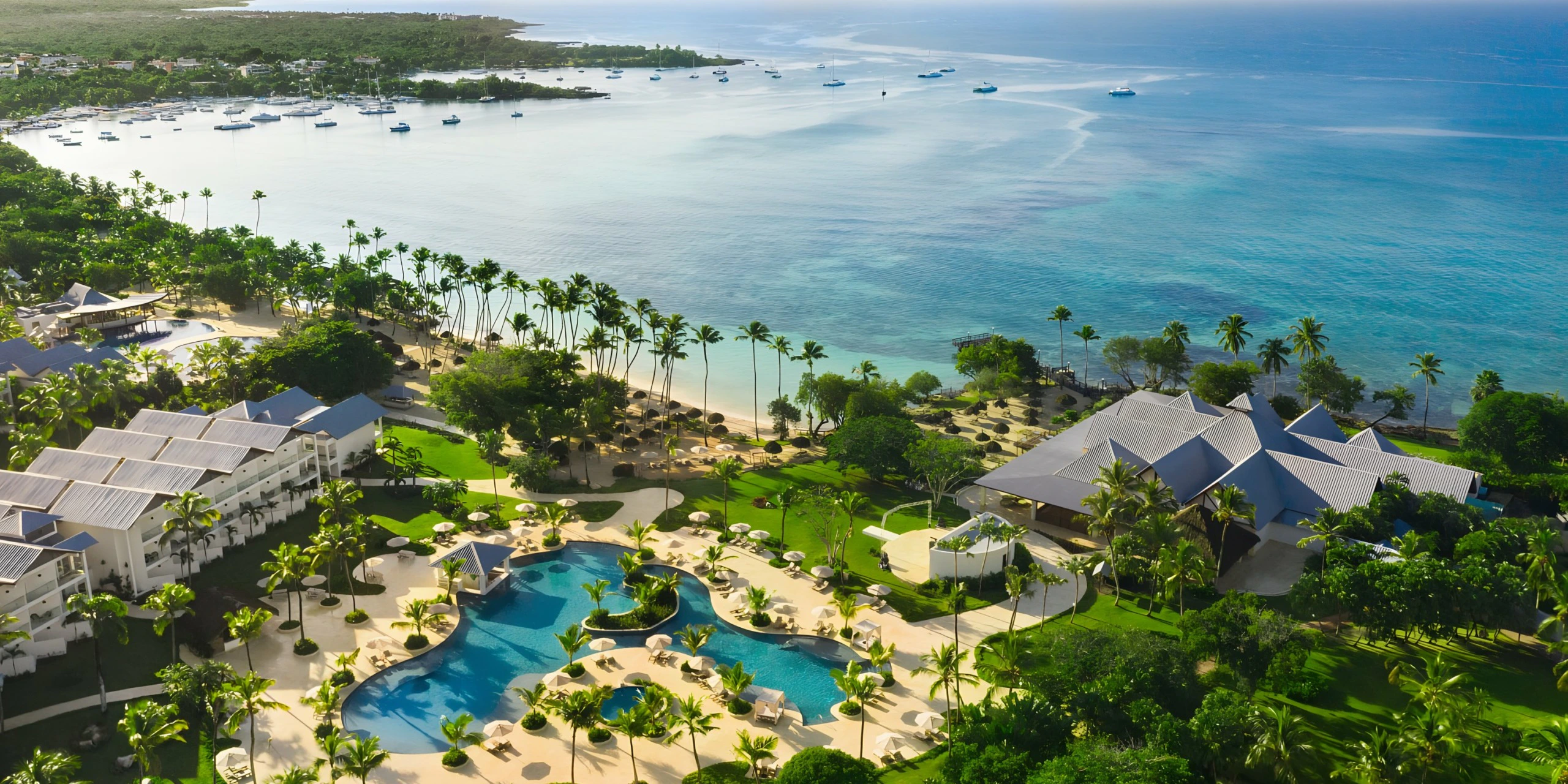Aerial view of Secrets La Romana Resort & Spa with pools, gardens, and Caribbean coastline.
