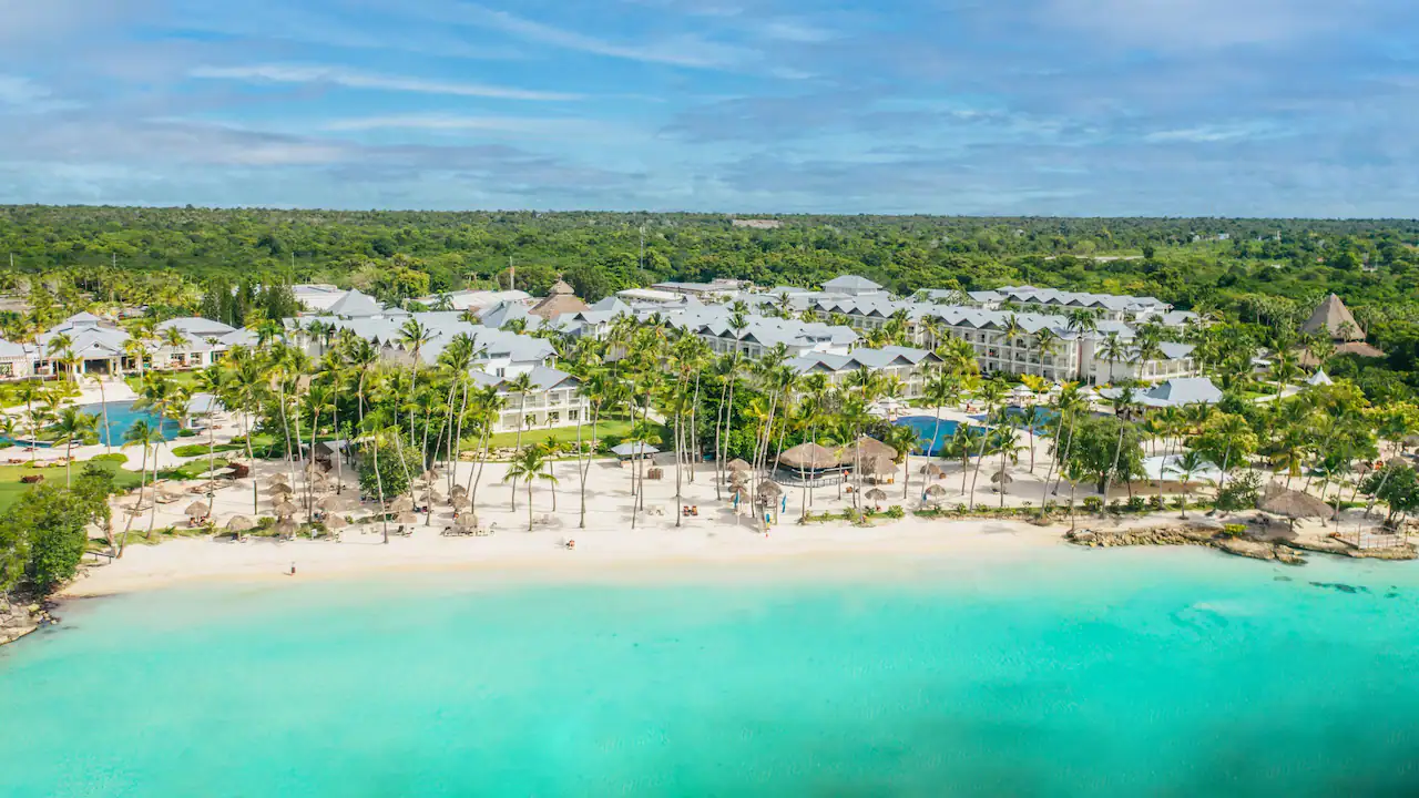 Aerial view of Secrets La Romana Resort & Spa with beachfront pools and tropical landscaping.
