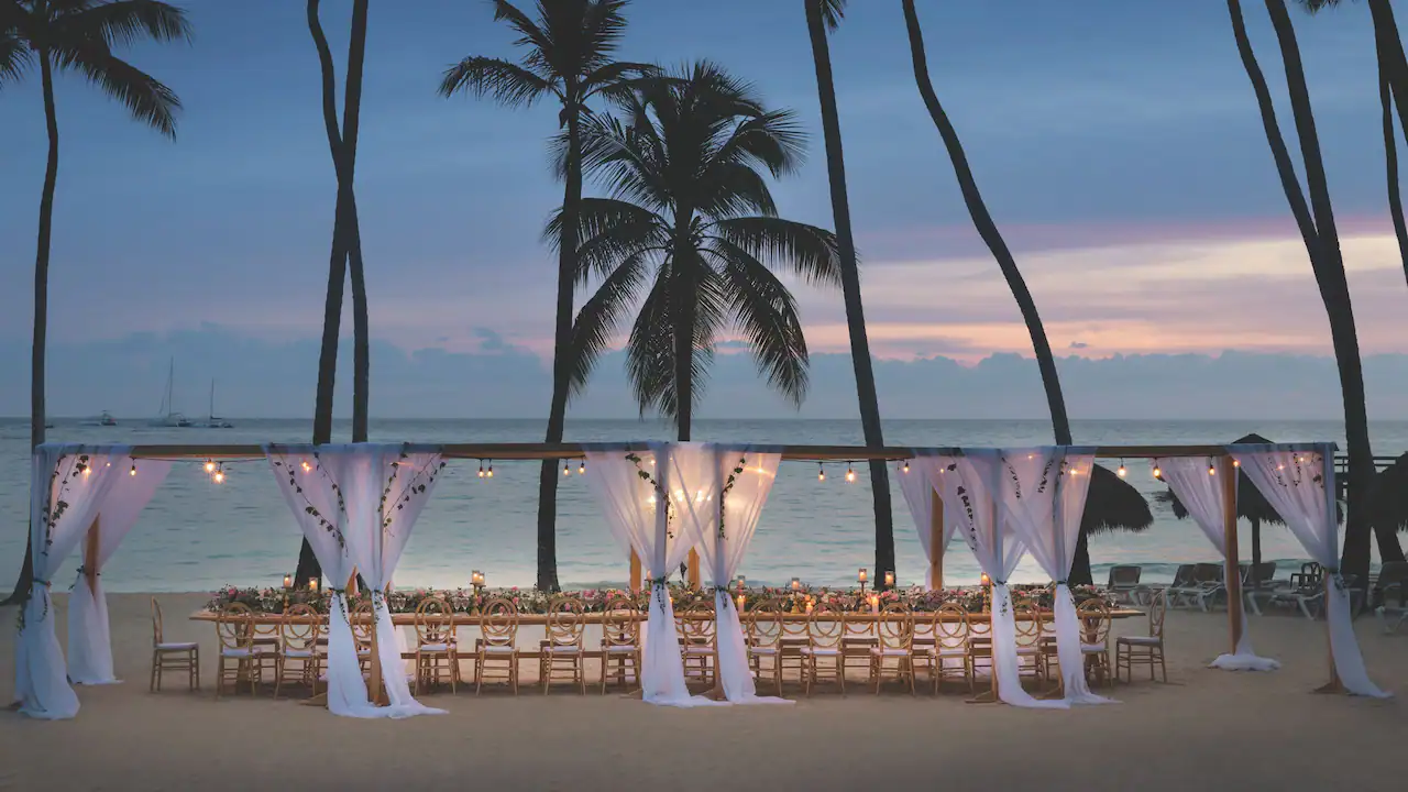 Elegant beachfront wedding reception setup at sunset at Secrets La Romana Resort & Spa.