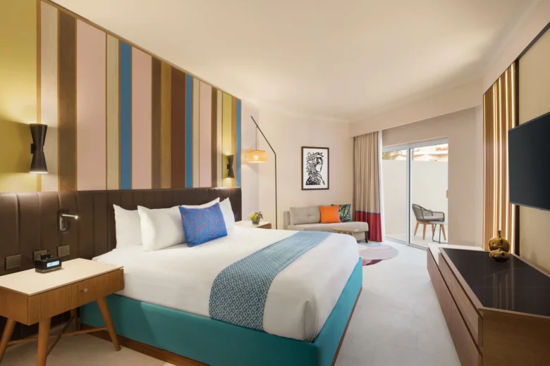 Deluxe Garden View king room with modern décor and private terrace at Secrets La Romana Resort & Spa.