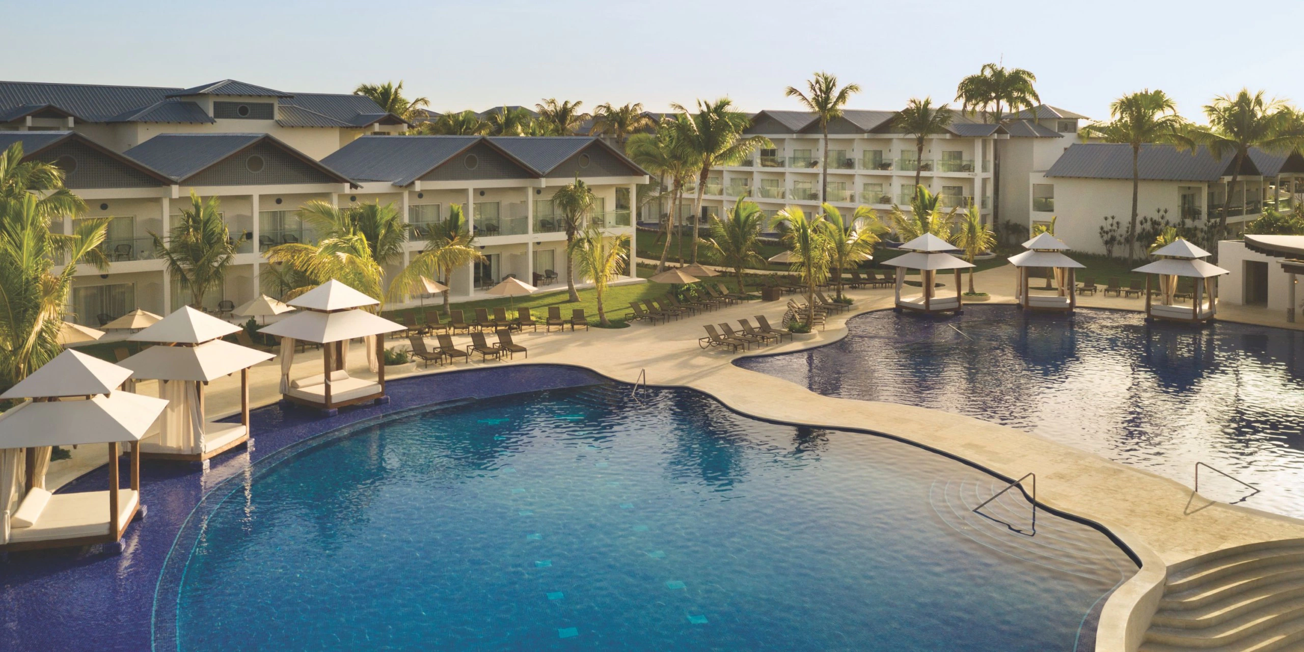 Large infinity-style resort pool with cabanas at Secrets La Romana Resort & Spa.