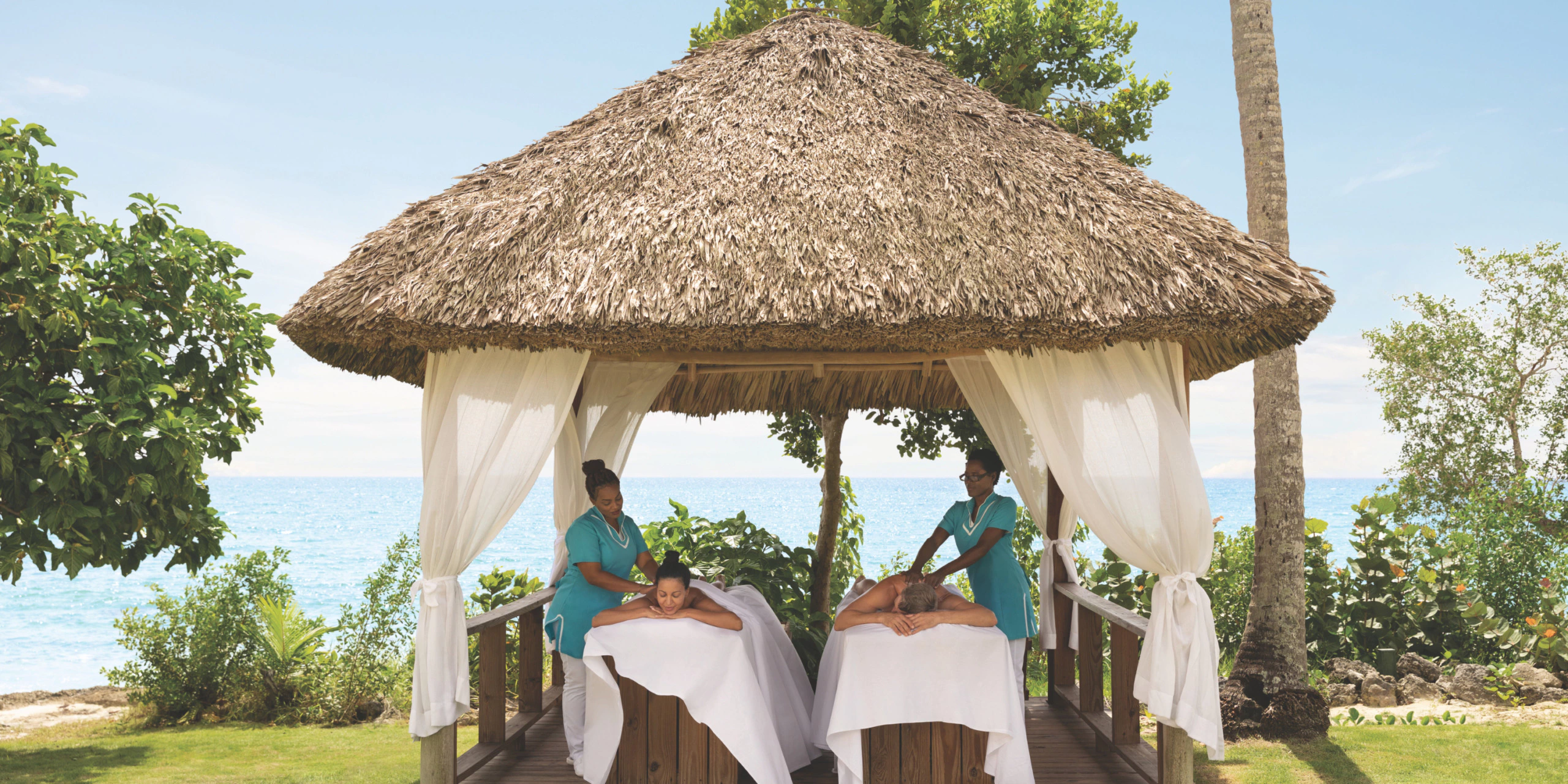 Guests enjoying outdoor oceanfront spa treatments at Secrets La Romana Resort & Spa.
