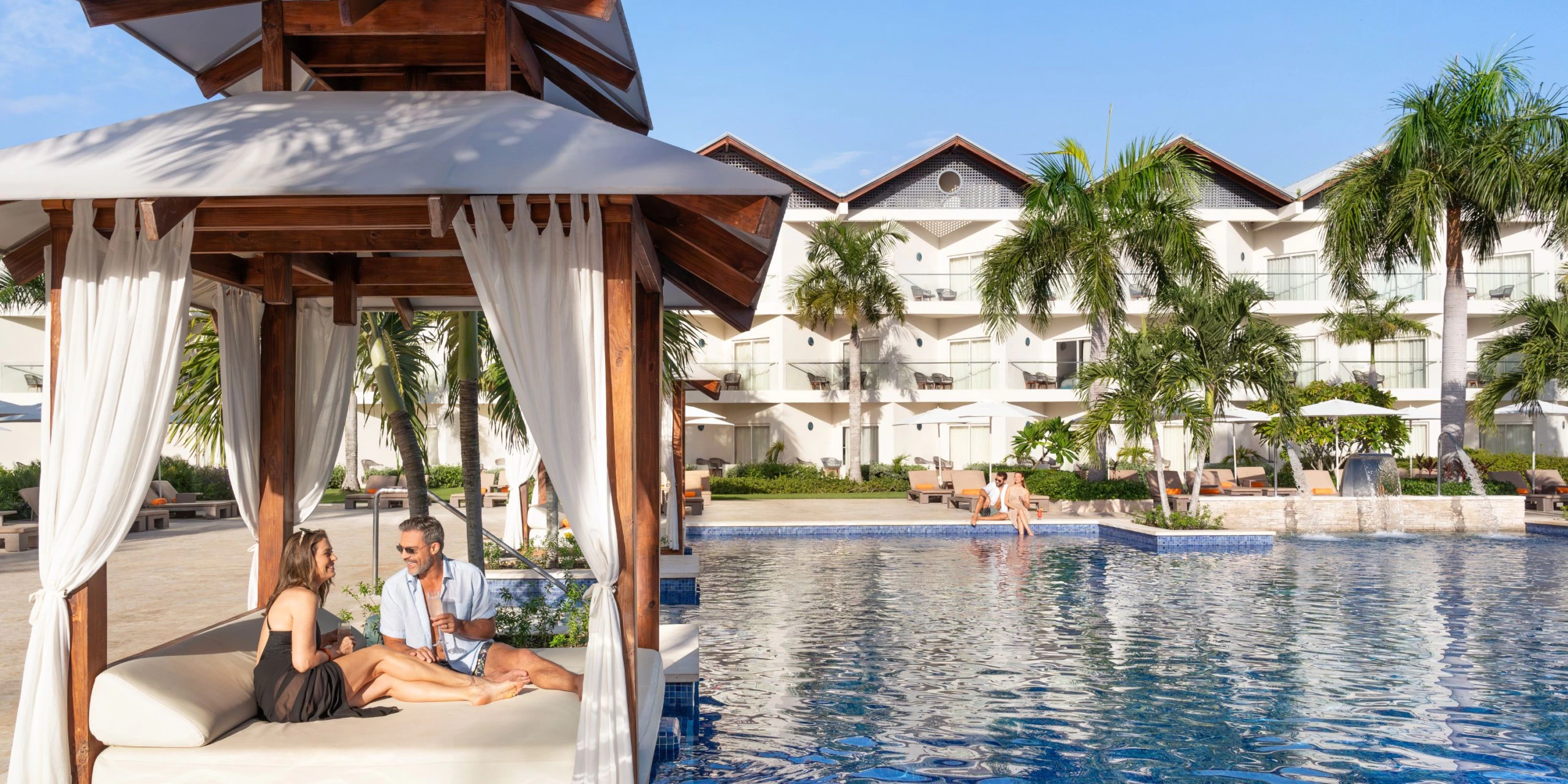 Couple relaxing in a poolside cabana at Secrets La Romana Resort & Spa.
