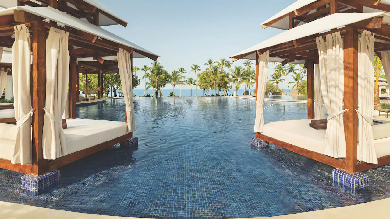 Elegant poolside cabanas overlooking the infinity pool at Secrets La Romana Resort & Spa.