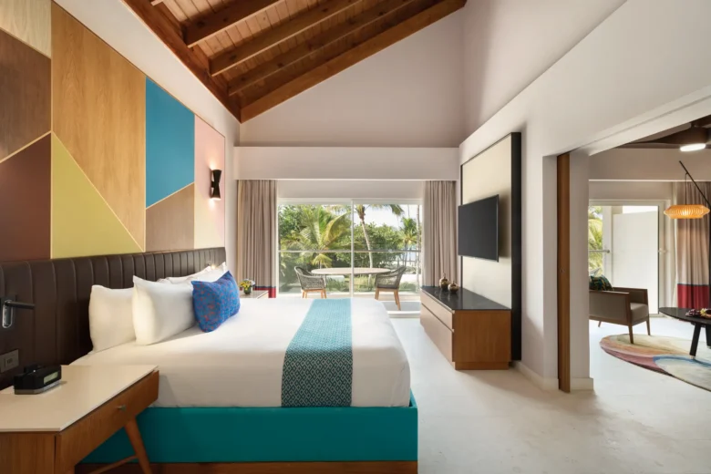Preferred Club Garden View suite bedroom with king bed and furnished balcony at Secrets La Romana Resort & Spa.