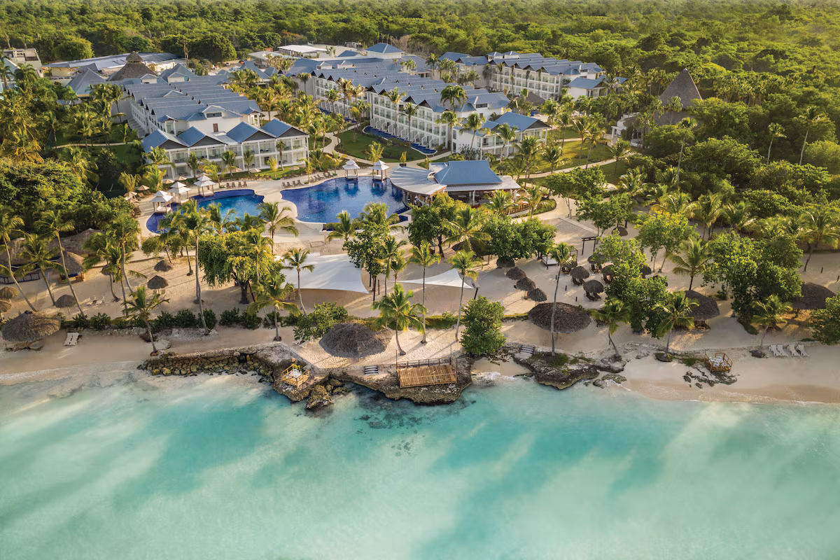 Aerial view of Secrets La Romana Resort & Spa featuring tropical pools, beachfront cabanas, and turquoise Caribbean waters.